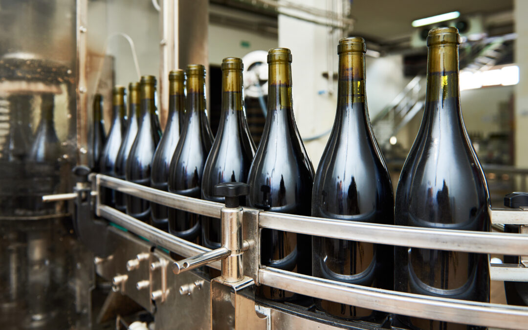 Bouteilles de vin sur une ligne de production avant l’exportation - Logistique et transport viticole international avec Planet Aura.