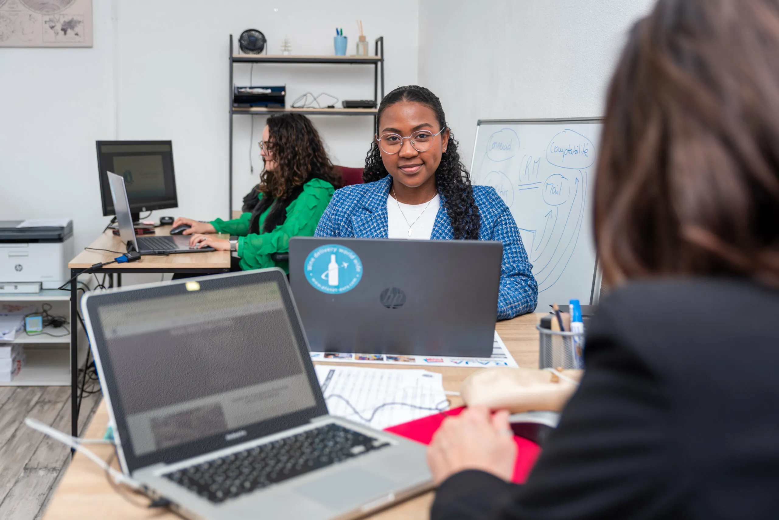 Équipe de support client de Planet Aura, travaillant en collaboration depuis le bureau pour garantir la satisfaction des exportateurs de vins.